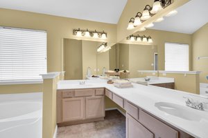 Expansive space with dual sinks, lighting and natural-toned cabinetry