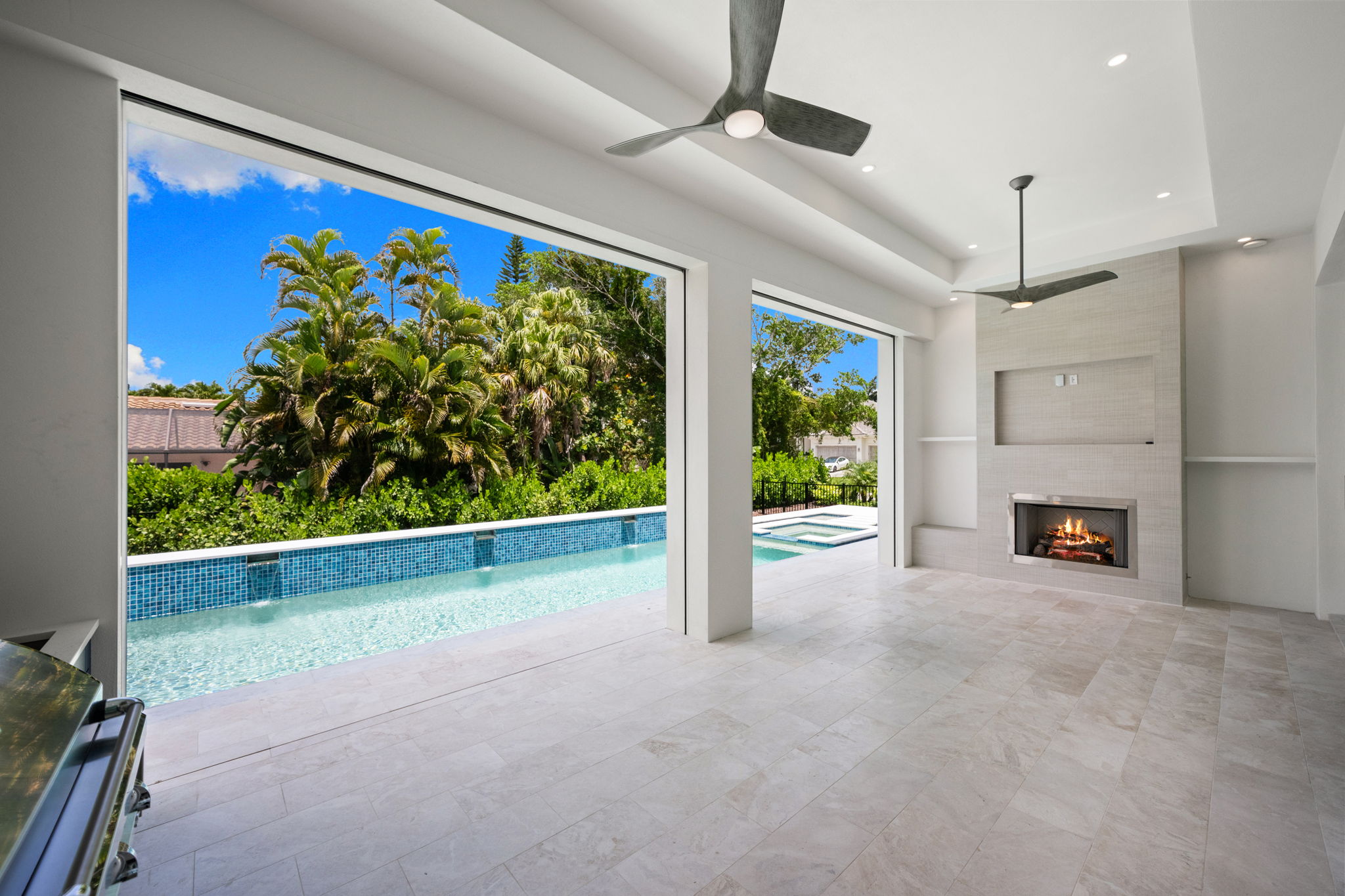 Spacious covered outdoor area with fireplace and built in TV area and shelving