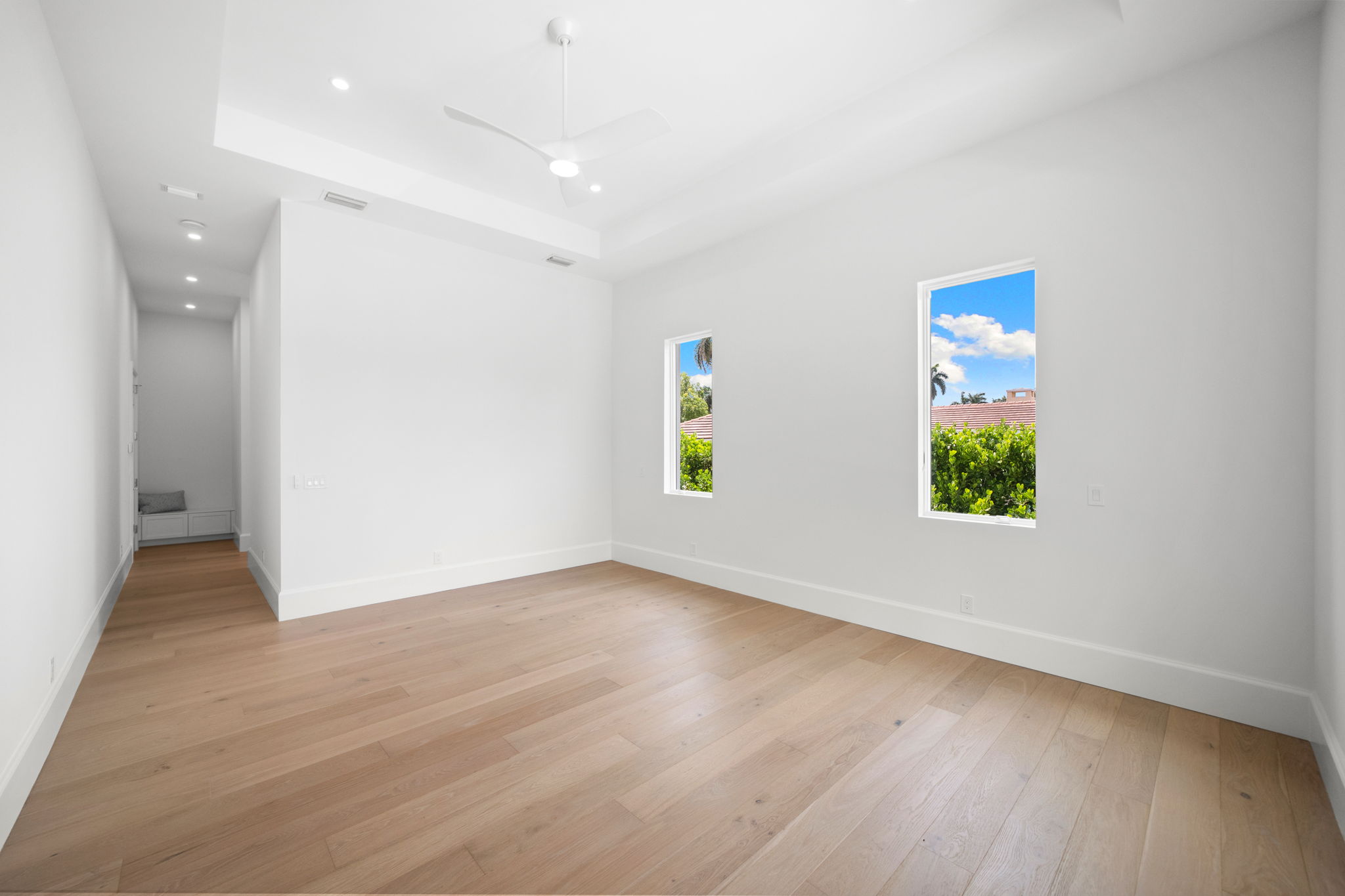 Gallery style hallway in primary leading to bath and storage/sitting bench