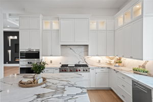 Kitchen featuring oversized island with mitered quartz countertops