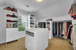 The redesigned primary closet has almost 20 linear feet of hanging, 5 storage units, dresser island & ironing board space!