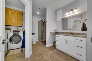 A well designed bathroom and adjacent laundry room with cuboards and ample storage.