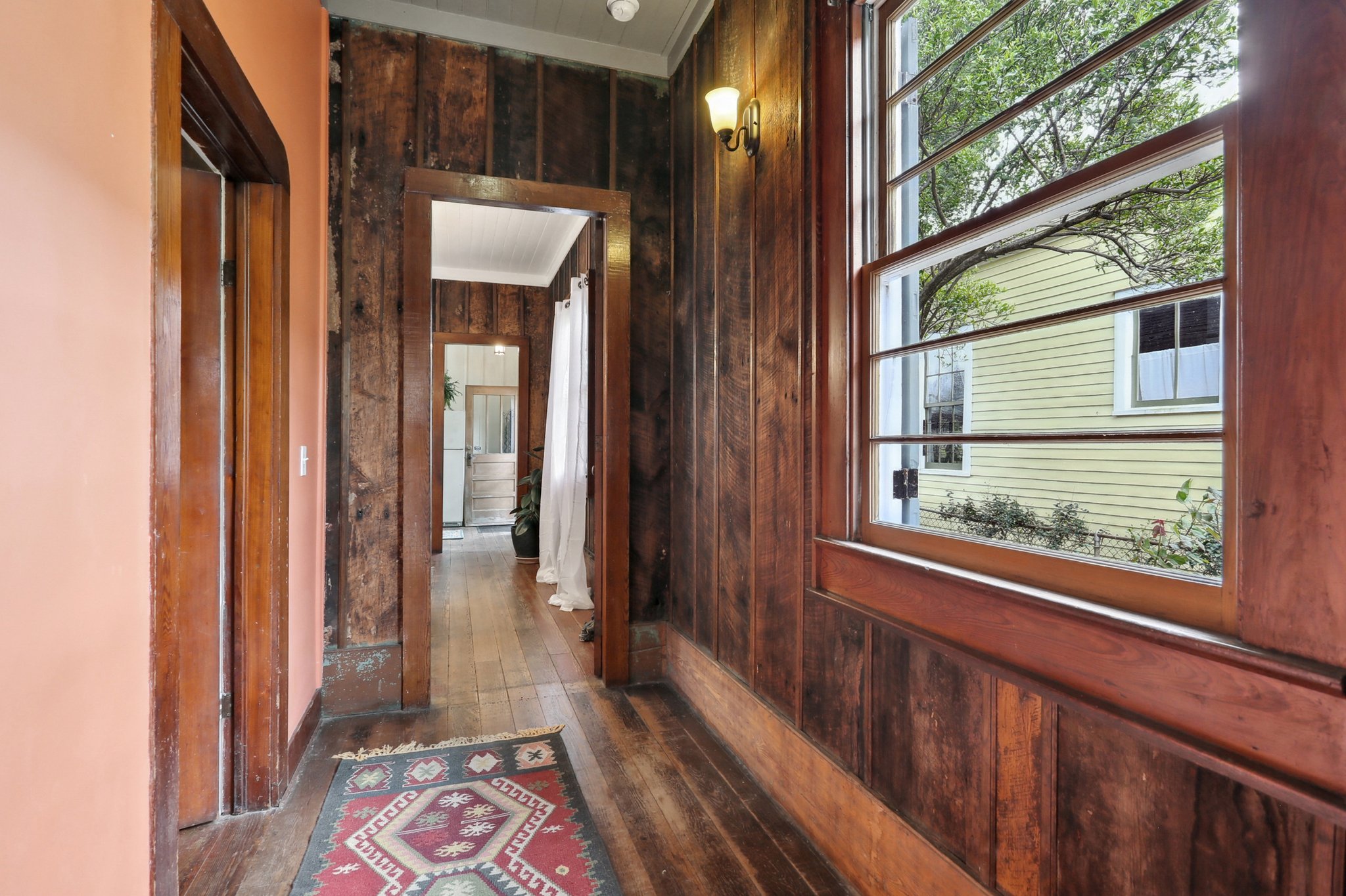 A hallway separates the two bedrooms, with the bathroom situated off of the hallway. The walls illustrate the historic barge board construction of the home.
