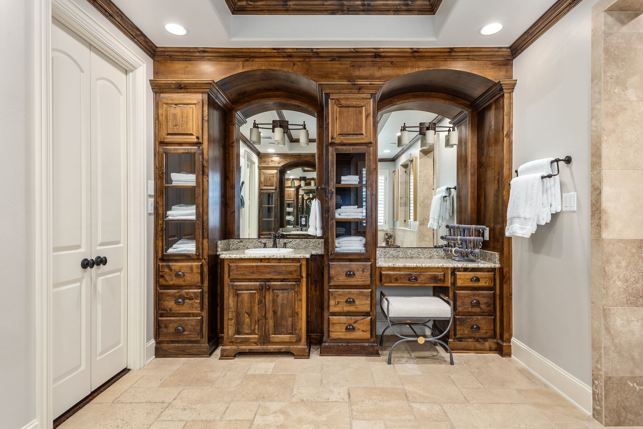 Primary suite spa-like bath with dual sinks and vanity with seating