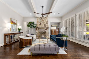 Living room with stone fireplace, beamed ceilings and an abundance of natural light