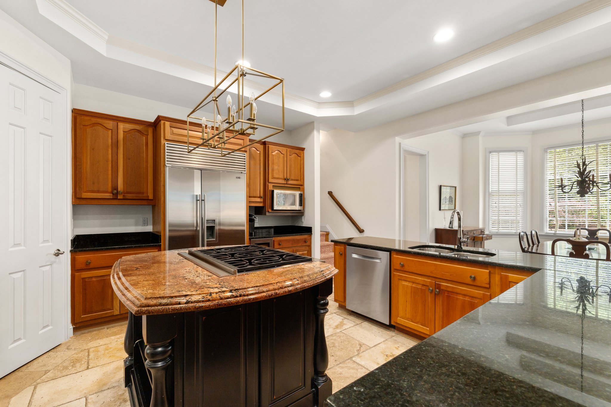 Wolf 6 burner gas stove with down draft range, chandelier, and recessed lighting.