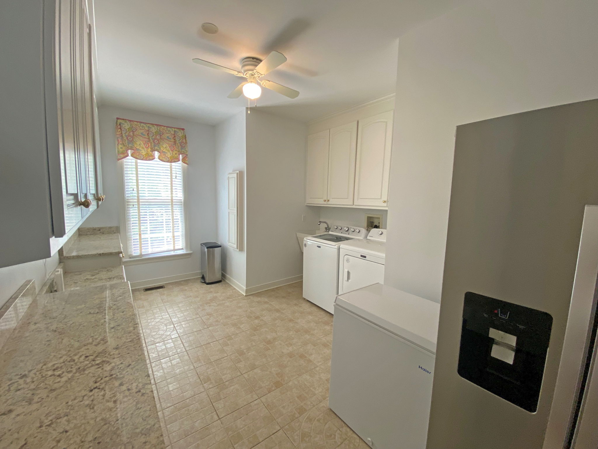 Huge laundry room with brand new washer and dryer, plenty of cabinet space, and granite countertops. Refrigerator conveys.