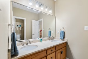 Jack and Jill bath with dual vanities and separate room with tub and toilet.