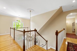 2nd floor landing has hardwood floors, palladian window, and walk up attic access.