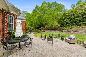 Massive paver patio that opens to a private backyard with paver stone retaining wall.