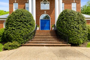 Beautiful brick steps to covered front porch with new front doors.