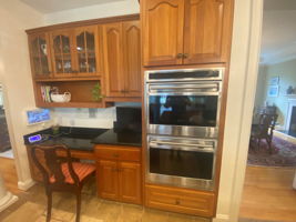 Built in desk with intercom system and double wall ovens one of which is a convection oven.
