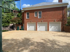 Huge 3 car garage with space for storage with a large aggregate driveway for parking multiple cars or enjoying a game of pick up basketball.