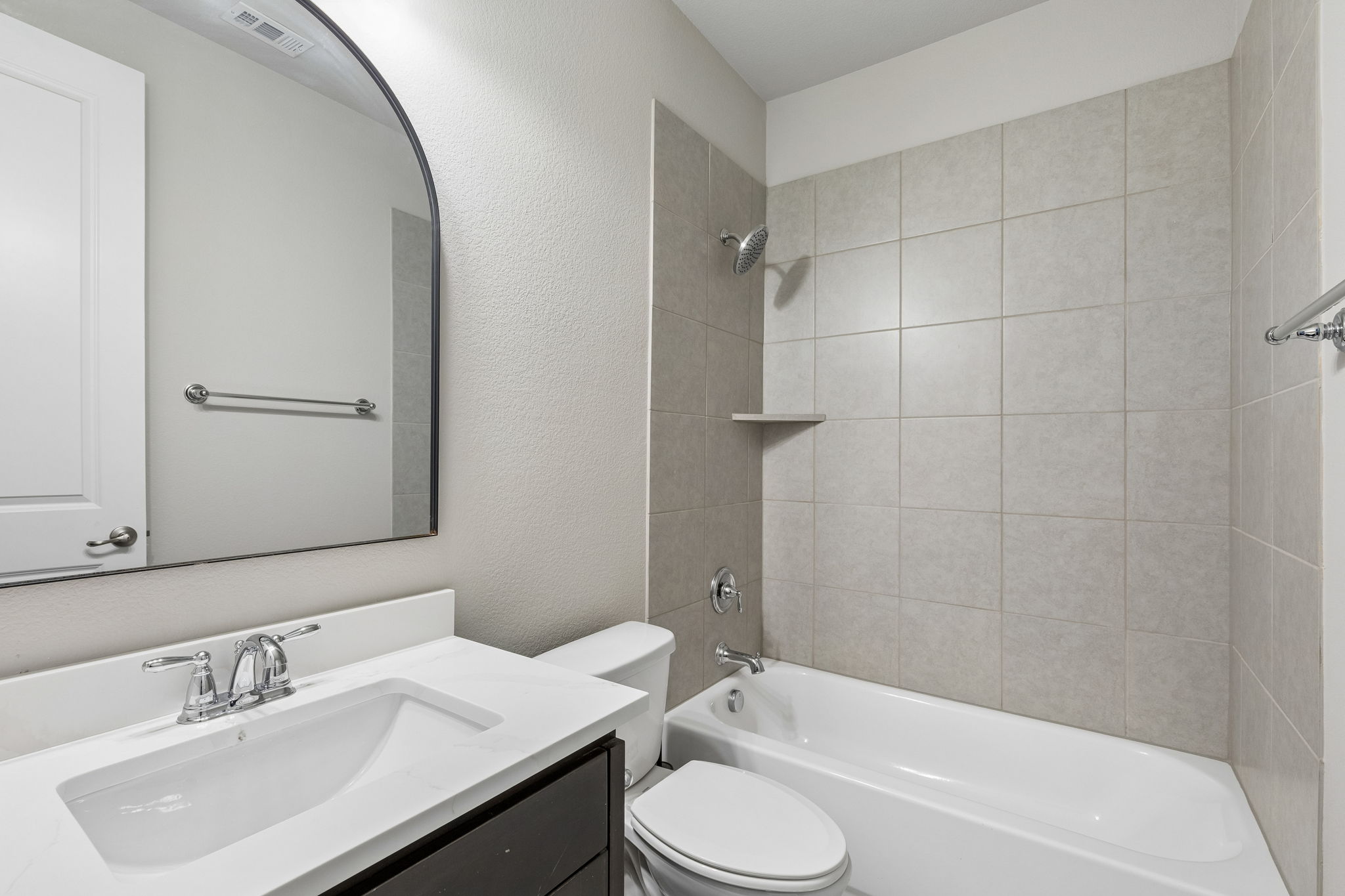 The first-floor guest bath is refreshed with a new 2026 quartz countertop and offers a full tub/shower combination.