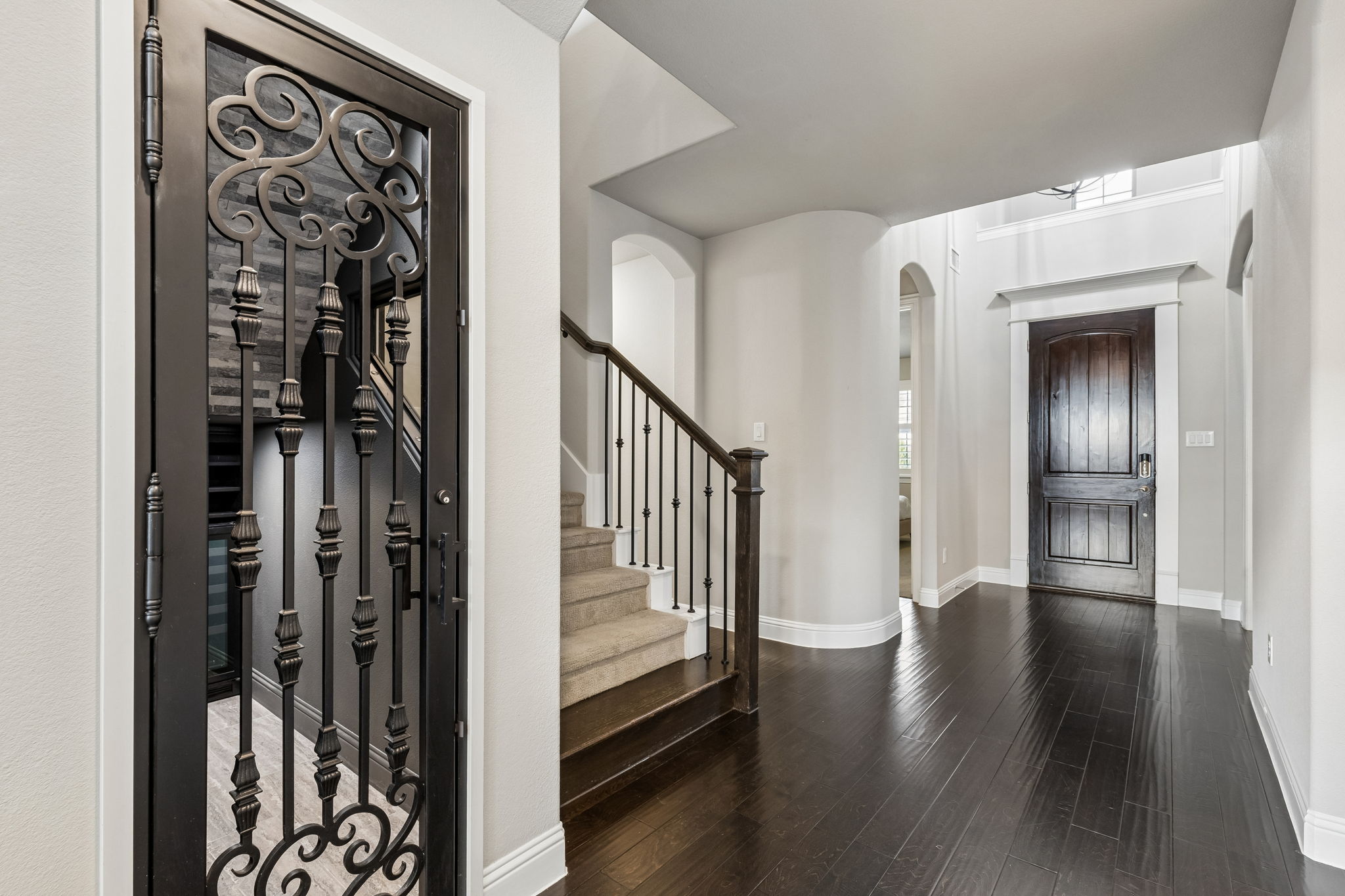 A custom wrought iron door welcomes you to your own 251+ bottle wine cellar