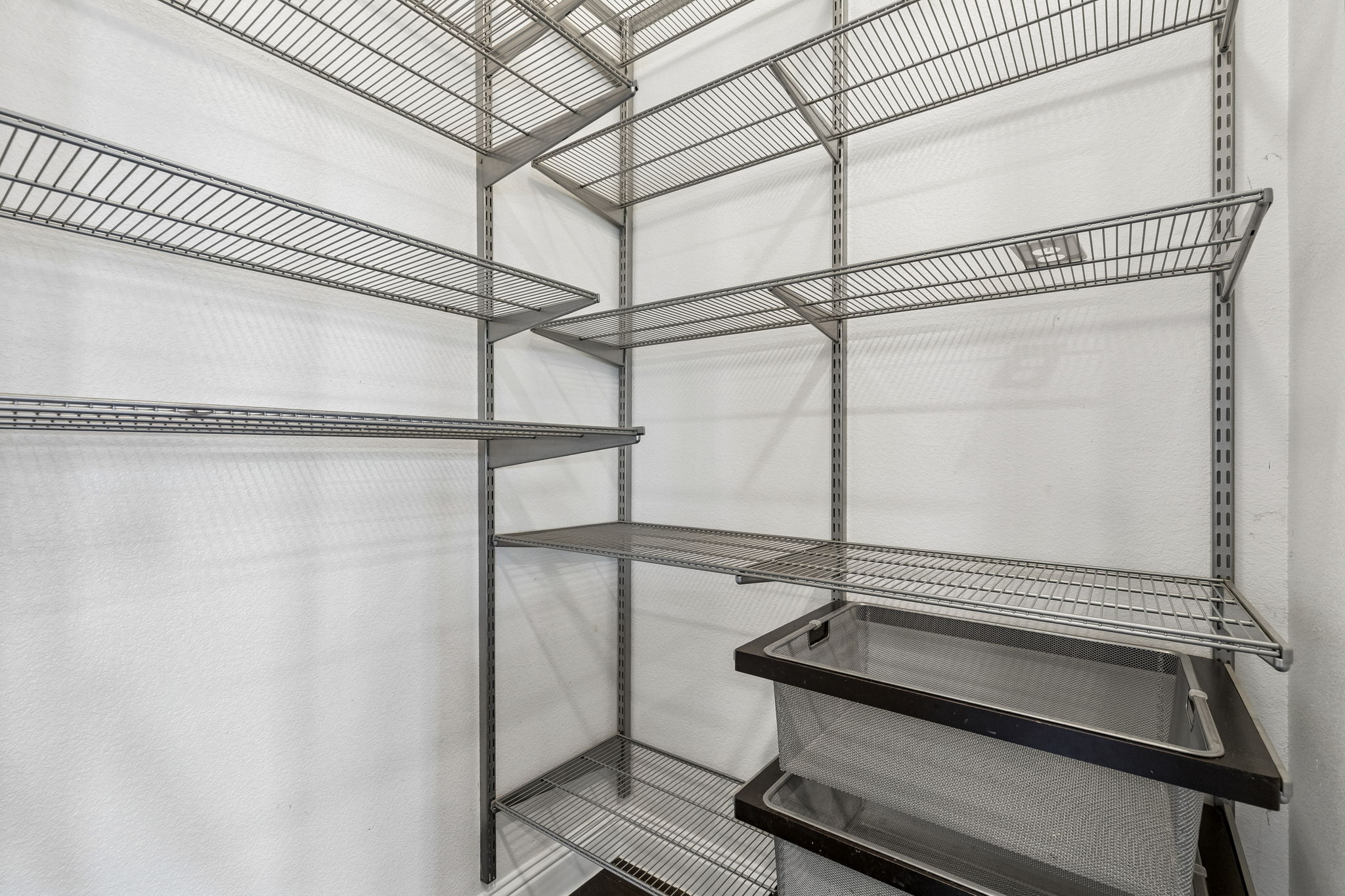 The walk-in pantry is outfitted with an Elfa storage system, providing abundant adjustable shelving and organized storage.