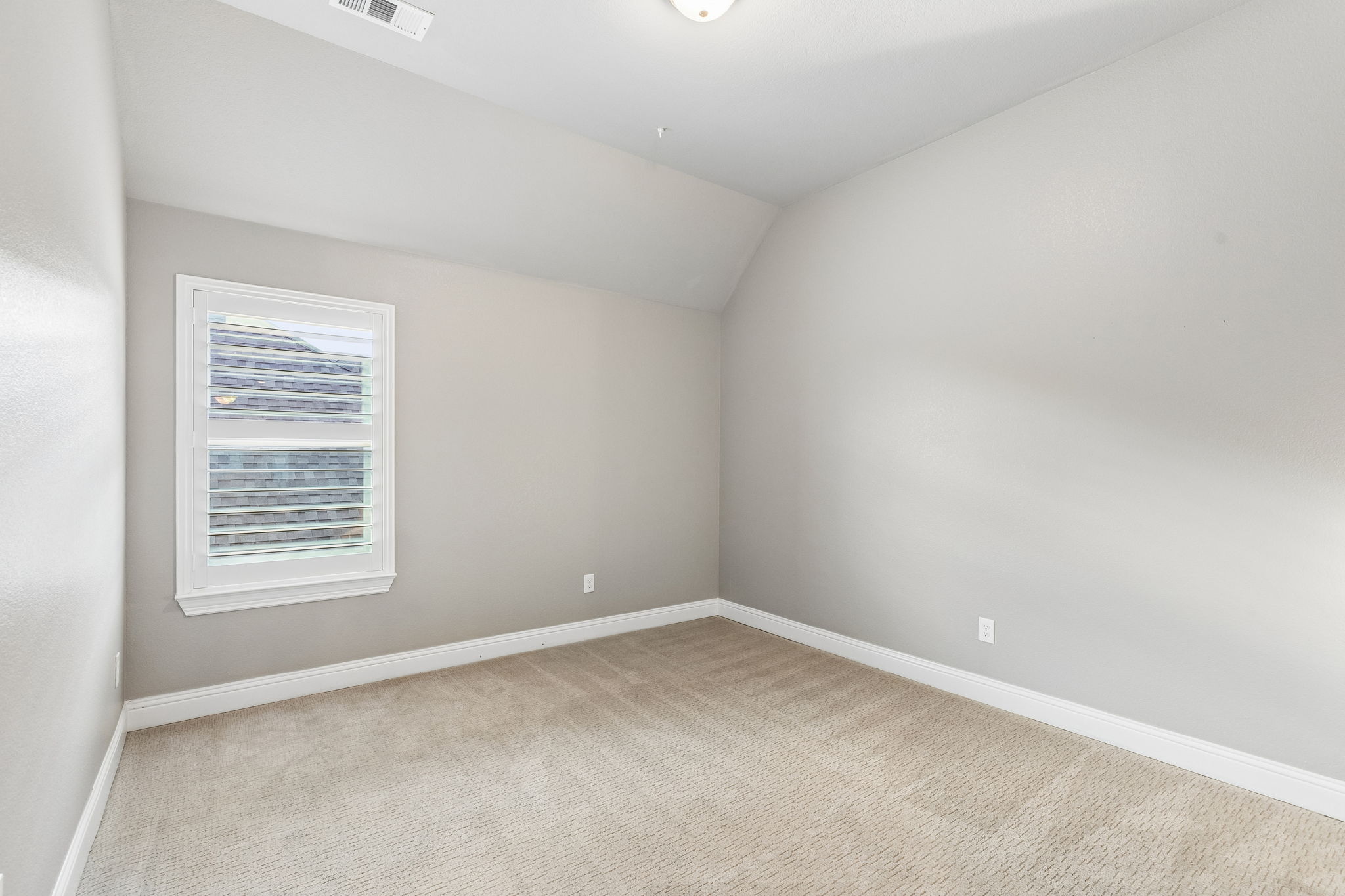secondary bedroom features recently installed carpet, plantation shutters and a neutral palette ready for personalization.