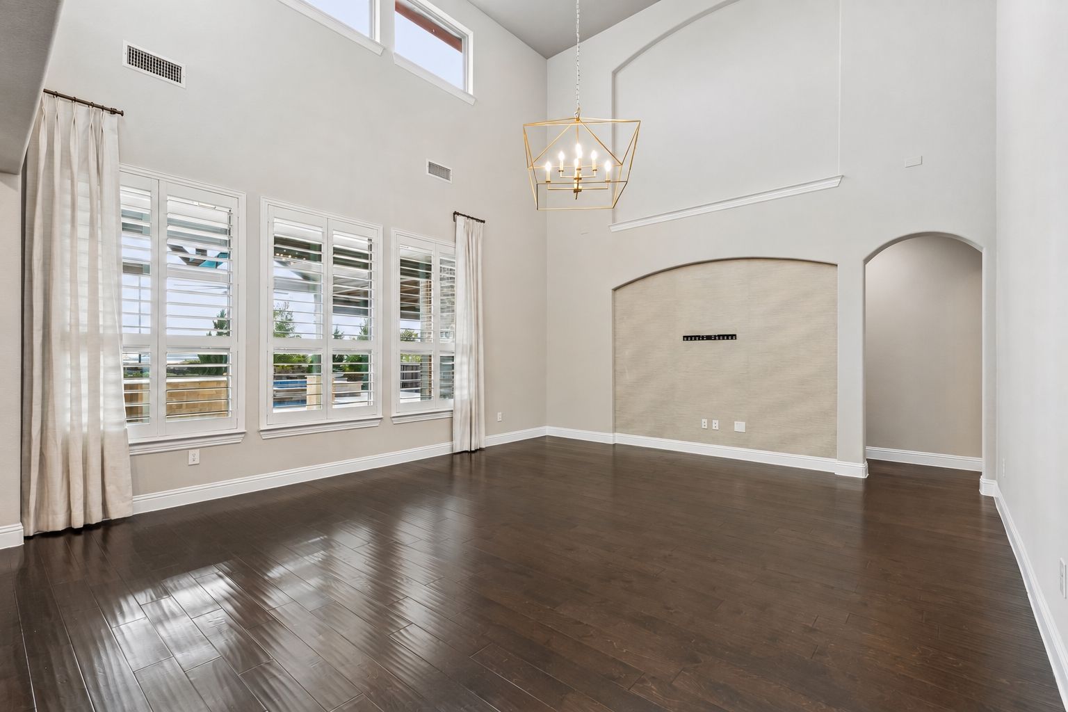 Soaring ceilings, plantation shutters, freshly recoated hardwood floors and a statement chandelier define the main living space