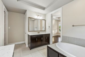 Dual vanities & garden tub, creating generous space within the primary bath. Window does have light filtering roller shade under the roman shade.