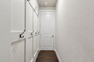 A dedicated mudroom/drop zone offers built-in board-and-batten detail with multiple hooks, creating a convenient everyday landing space just off the garage