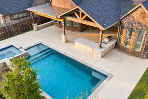 Multiple entertaining zones, including the heated pool & spa, vaulted covered patio, cedar pergola and oversized granite bar with built-in grill.