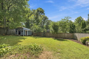 Flat back yard with large storage shed