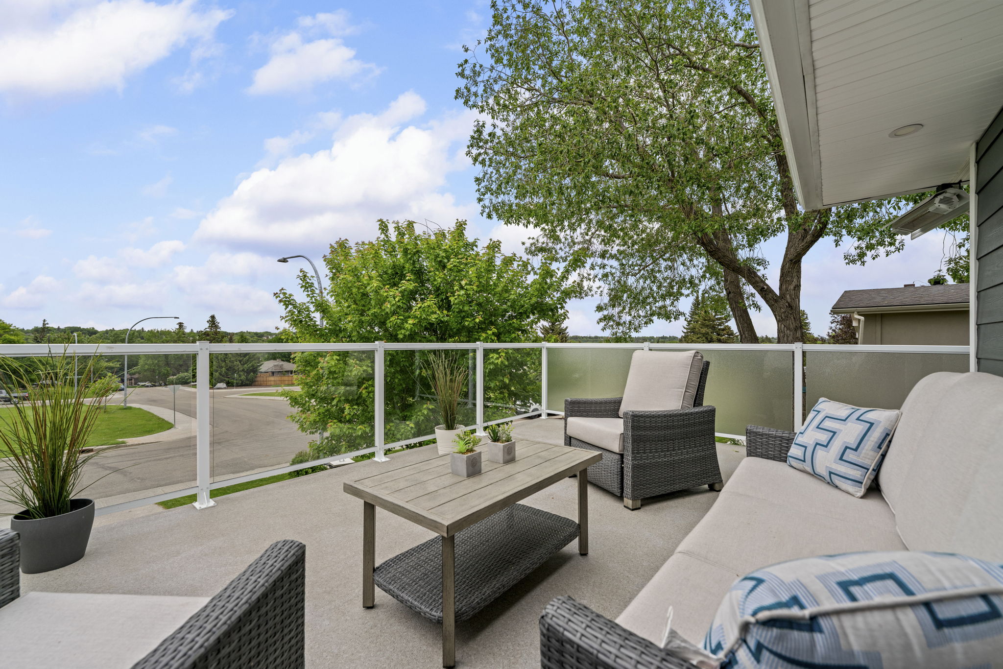 Front terrace seating area with a glass railing overlooking the street.