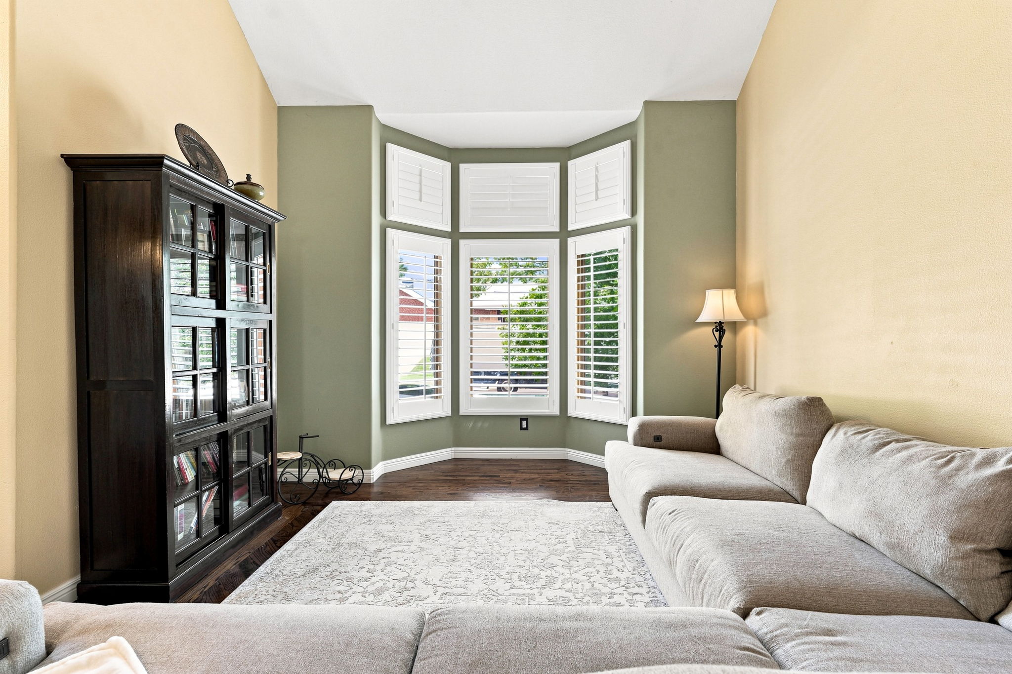 Formal living room with vaulted ceilings,  bay window, plantation shutters, hardwood flooring