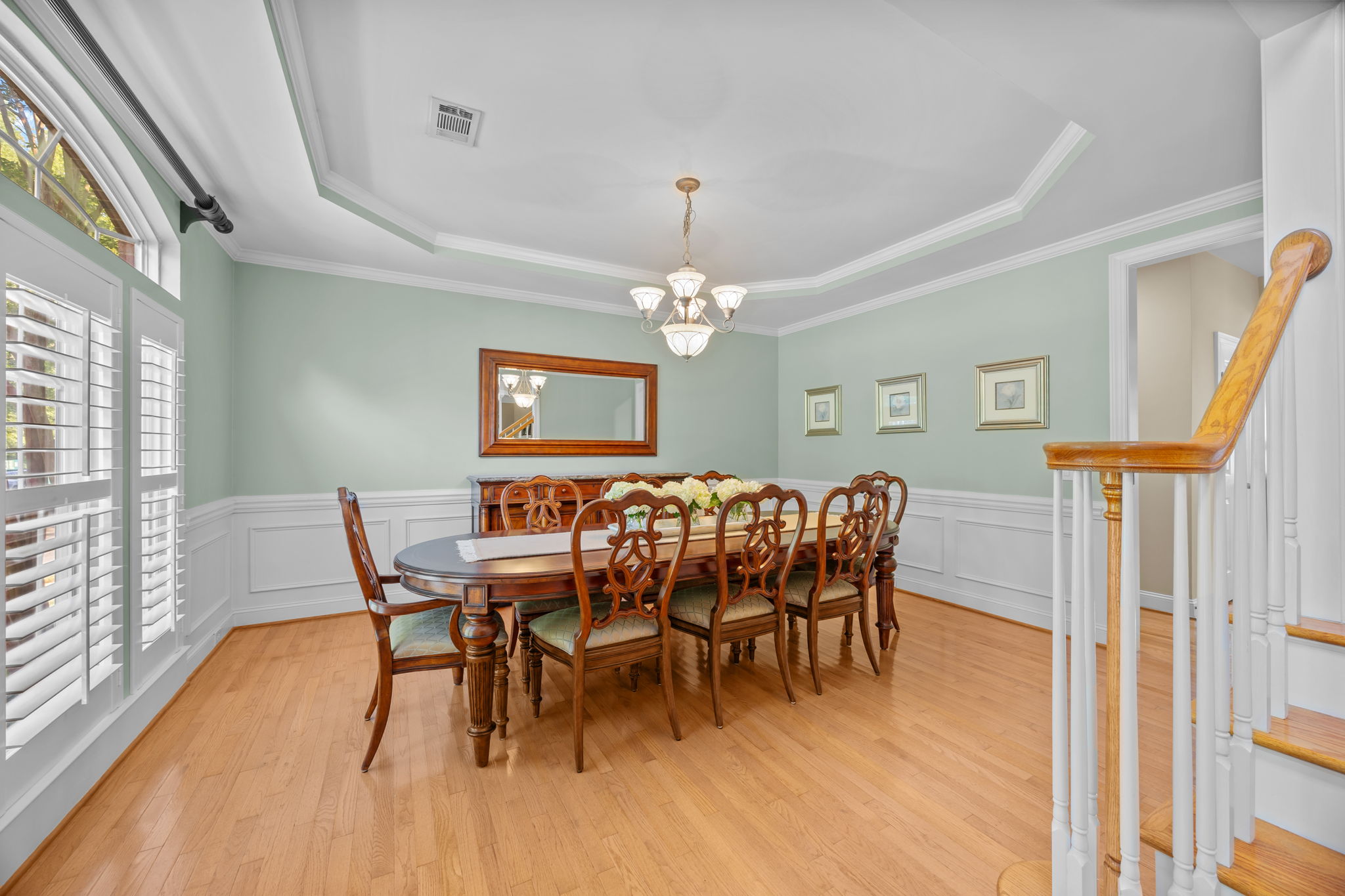Dining room with plantation shutters, tray ceiling and beautiful trim work