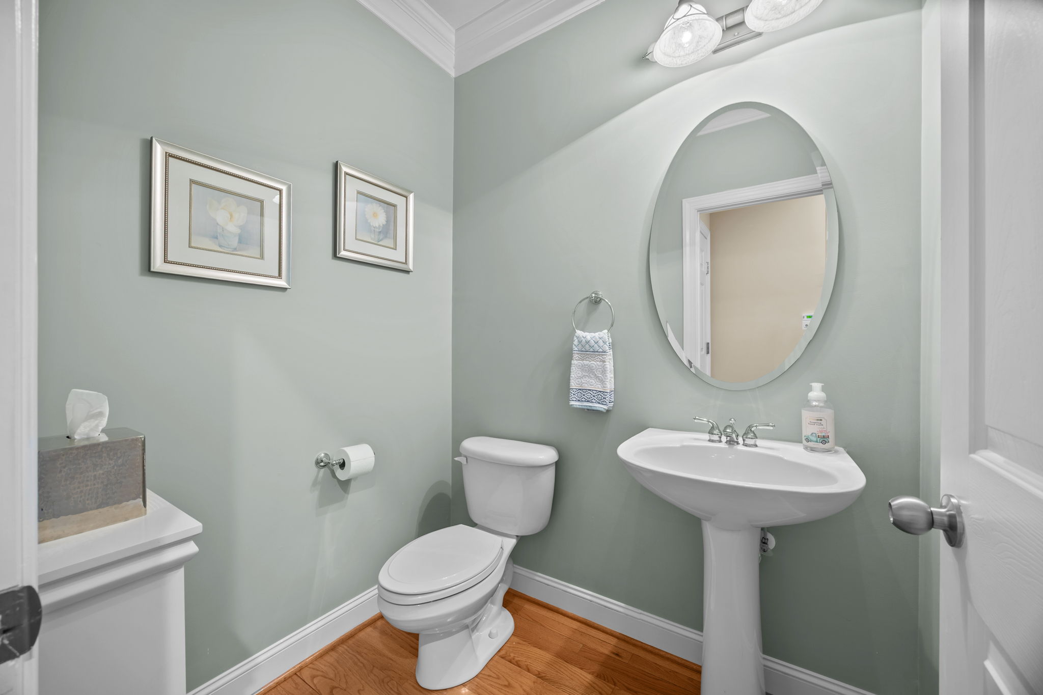 Powder room with crown molding off the kitchen hallway
