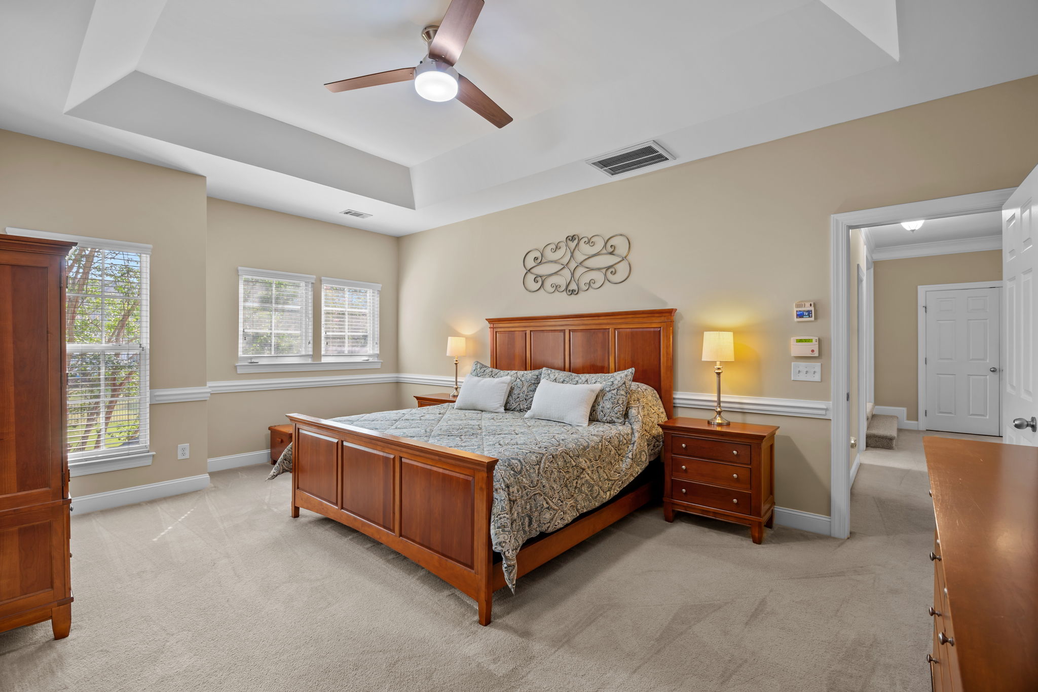Spacious primary bedroom (Bedroom 4) with tray ceiling and ceiling fan