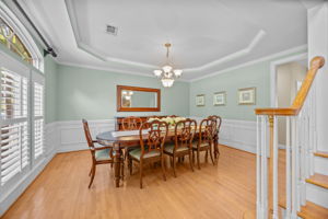 Dining room with plantation shutters, tray ceiling and beautiful trim work