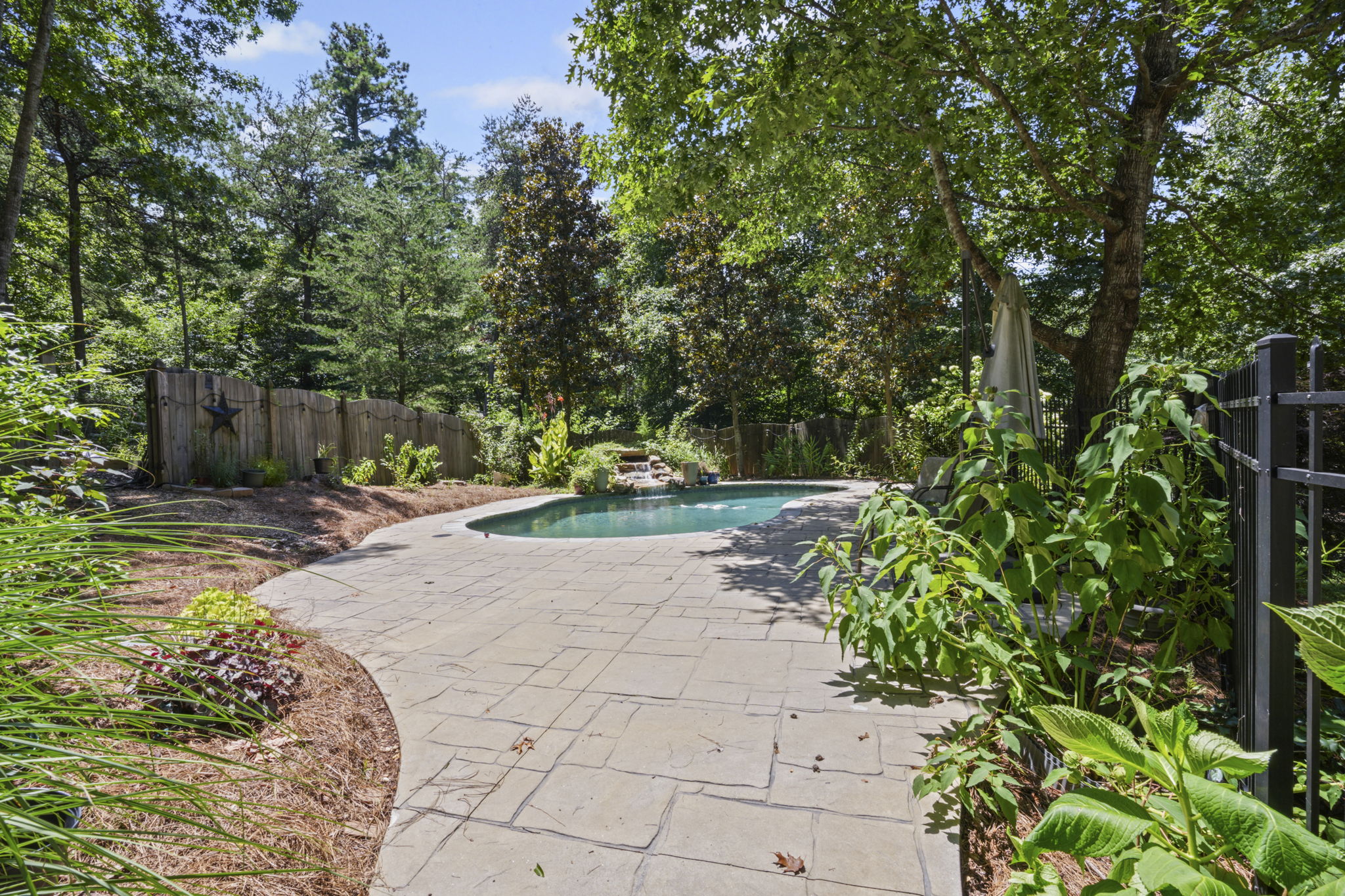 Gated black wrought iron fence leads to your backyard oasis!