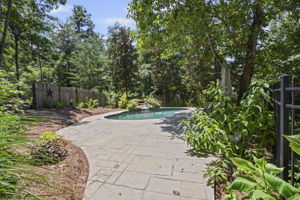 Gated black wrought iron fence leads to your backyard oasis!