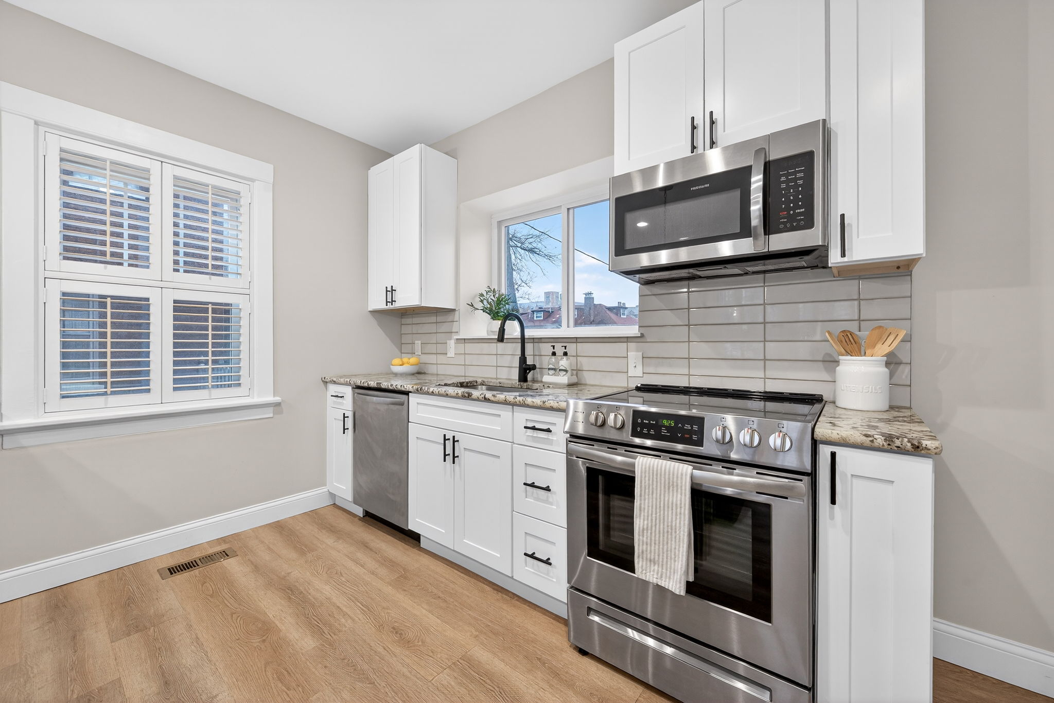 The fully-renovated kitchen features granite countertops, breakfast bar, solid wood cabinetry and all stainless steel appliances included.