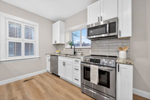 The fully-renovated kitchen features granite countertops, breakfast bar, solid wood cabinetry and all stainless steel appliances included.