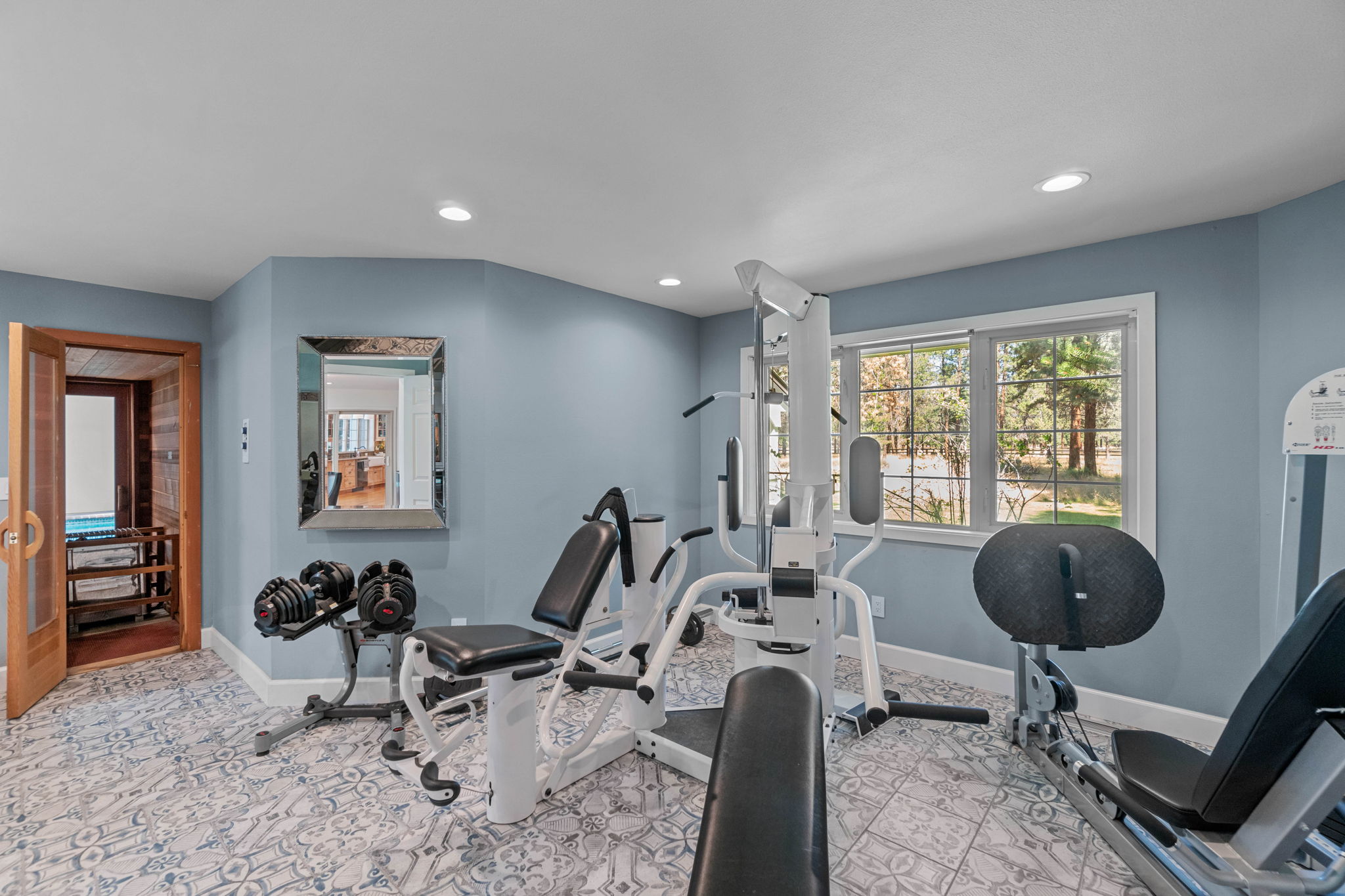 Home workout room offers high end equipment; Vector Weight Station 1850, Life Fitness Treadmill & wall mounted TV included