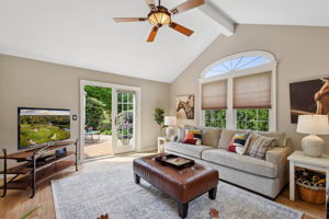 In the family room, the double French doors open wide to nature, blurring the line between indoor comfort and outdoor calm.