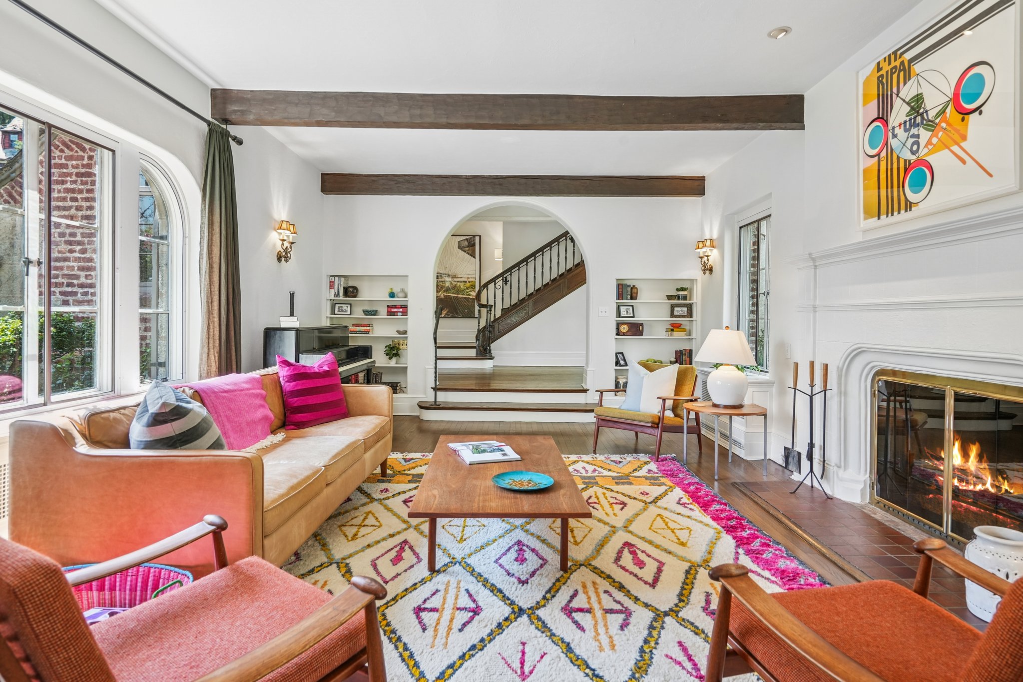 With windows on two sides, beamed ceilings above, and a wood-burning fireplace, this living room invites you to linger just a little longer.