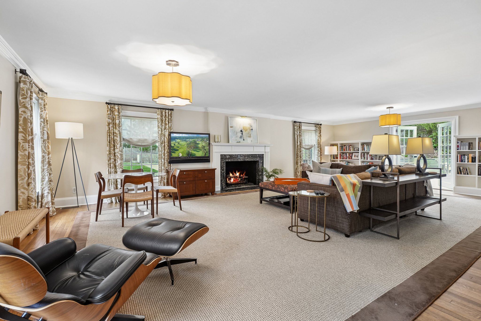 Comfortable living area with built-ins, pool views, gas fireplace and french doors out to patio.