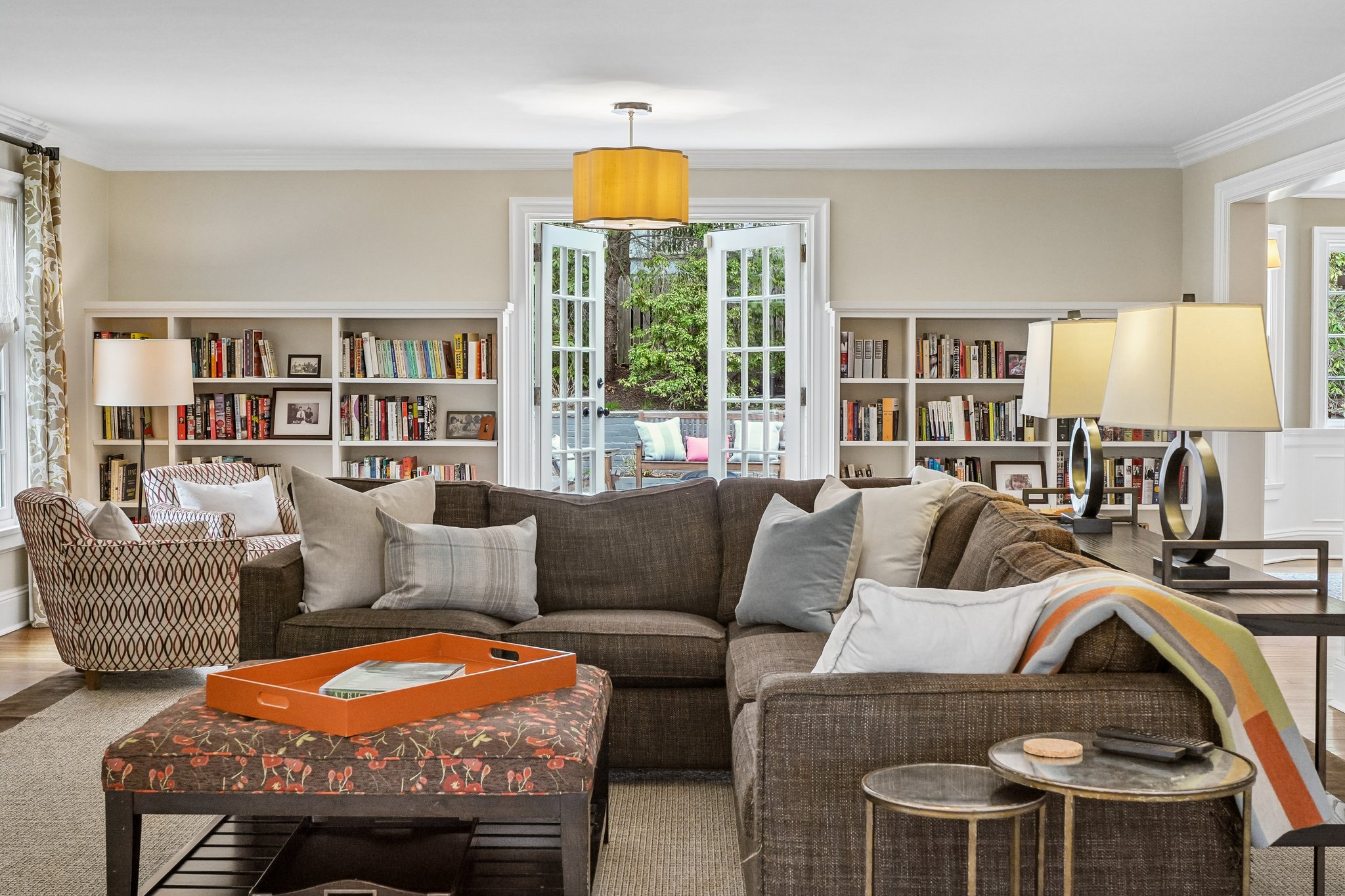 Freshly painted and filled with light, this living room draws you outward with doors to the patio and views of the pool beyond - a seamless connection between inside and out.