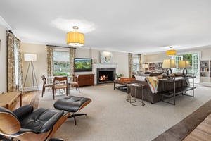 Comfortable living area with built-ins, pool views, gas fireplace and french doors out to patio.