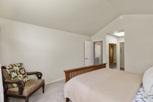 Another shot of the primary bedroom with vaulted ceilings.