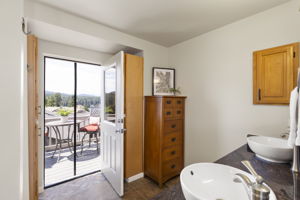 Primary bathroom with door to private view deck.