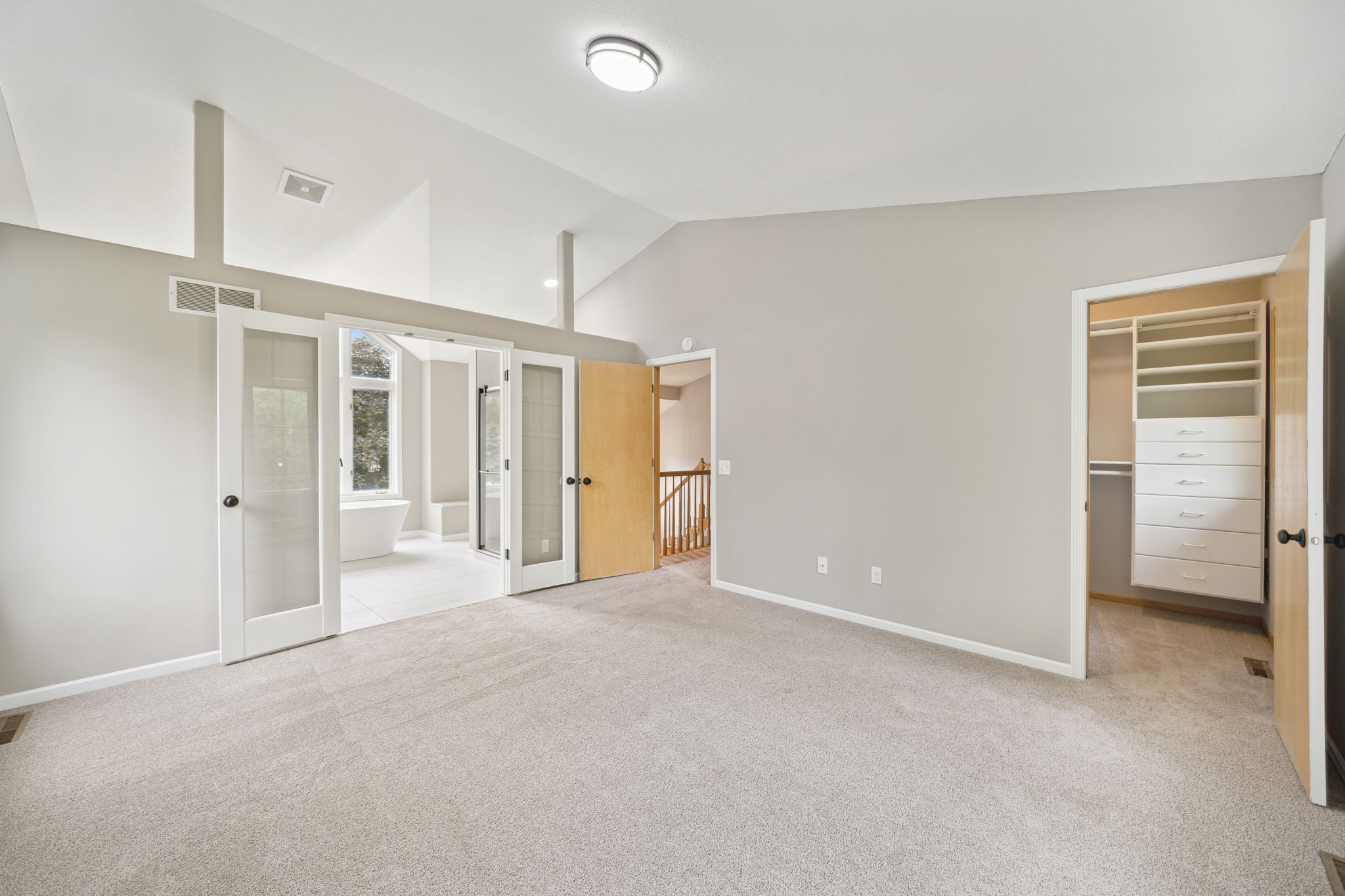 Upstairs in the Primary bedroom, vaulted ceilings, large walk-in closet and remodeled bath