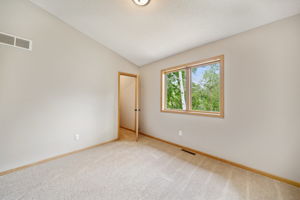 Second bedroom upstairs has a view of the backyard and has walk-in closet and vaulted ceiling