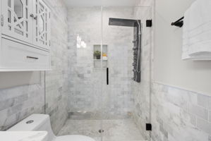 Walk-in shower with a glass enclosure and body jets