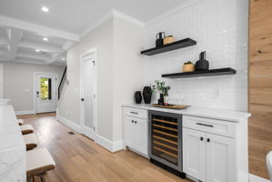 Beverage station with a wine refrigerator and open shelving
