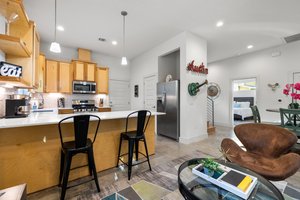 Gorgeous kitchen, breakfast bar, dining table for four, one bedroom on the lower level. The "Austin" sign and guitar do not convey (are not included in the sale).