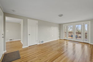 Open living room with French doors that open to deck